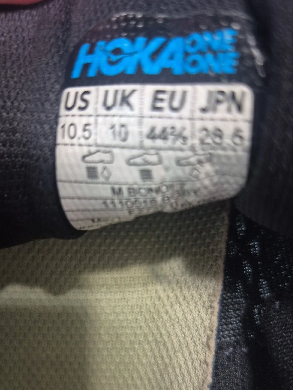 Hoka black running shoes with pale yellow logo
